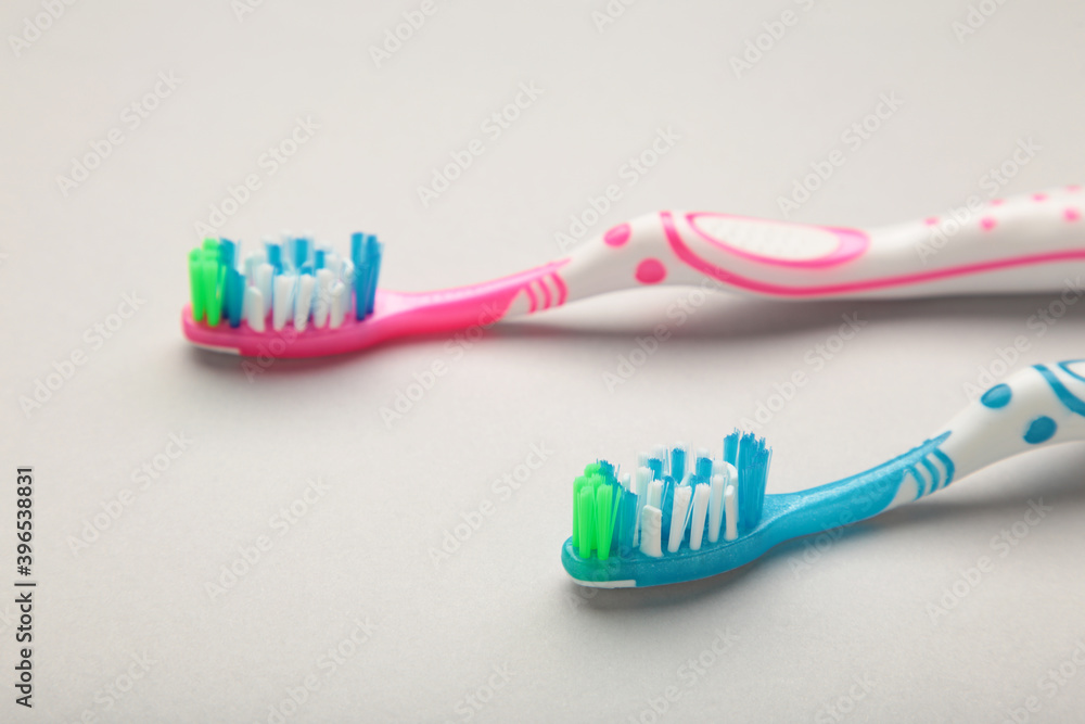 Two toothbrushes on grey background with copy space. Two toothbrushes on grey background with copy space.