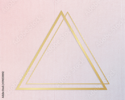 Gold ftriangle rame on a pinkish blue fabric background photo