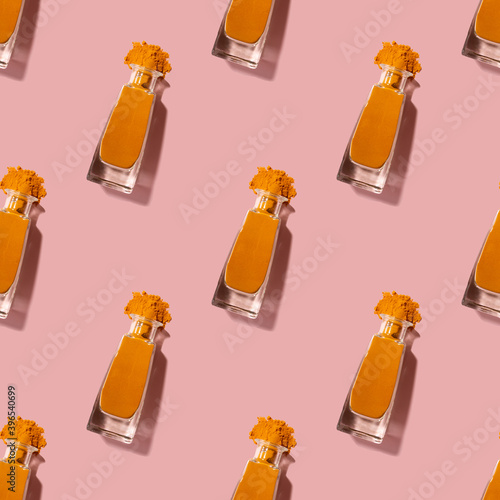 Seamless pattern with tumeric in crystal clear bottles.