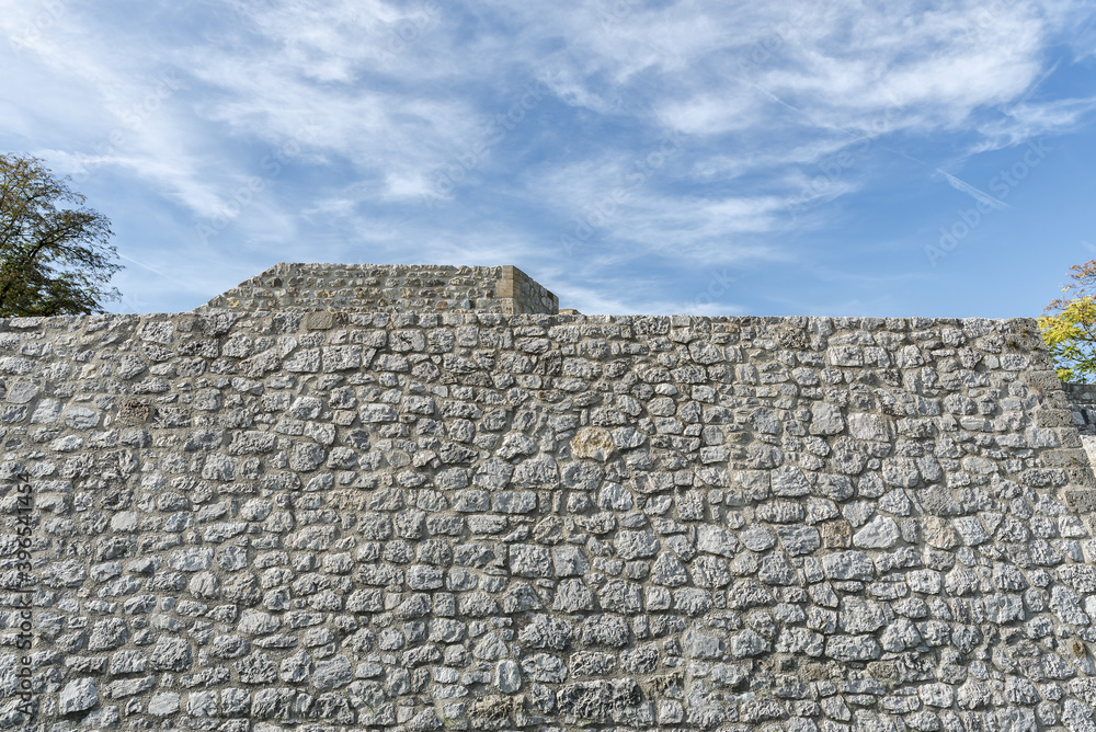 Historical stonewall aged pattern background with blue sky Historical stonewall aged pattern background with blue sky