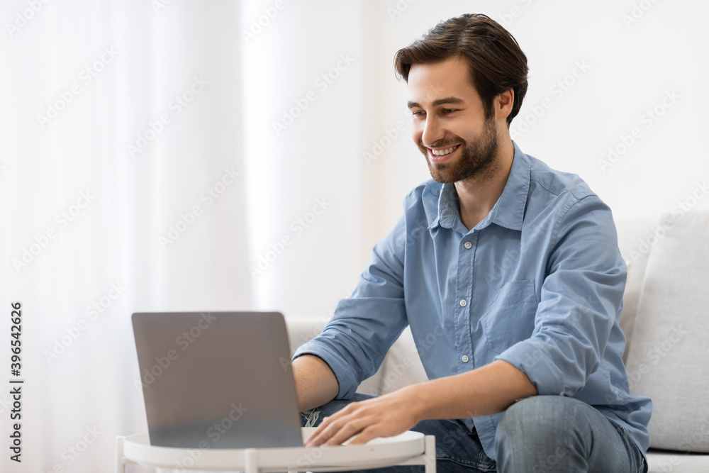 Successful Young Businessman At Laptop Working Sitting On Couch Indoor