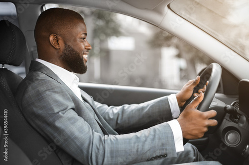 Joyful black businessman driving home after working day © Prostock-studio