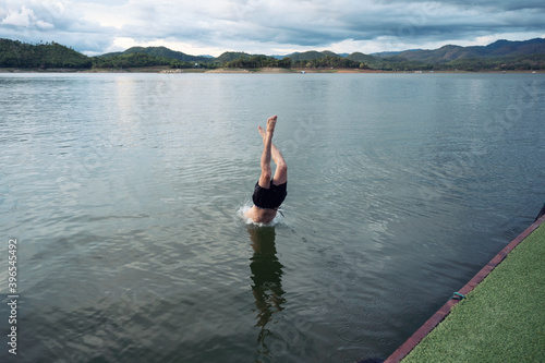 Young man diving into lake in dam