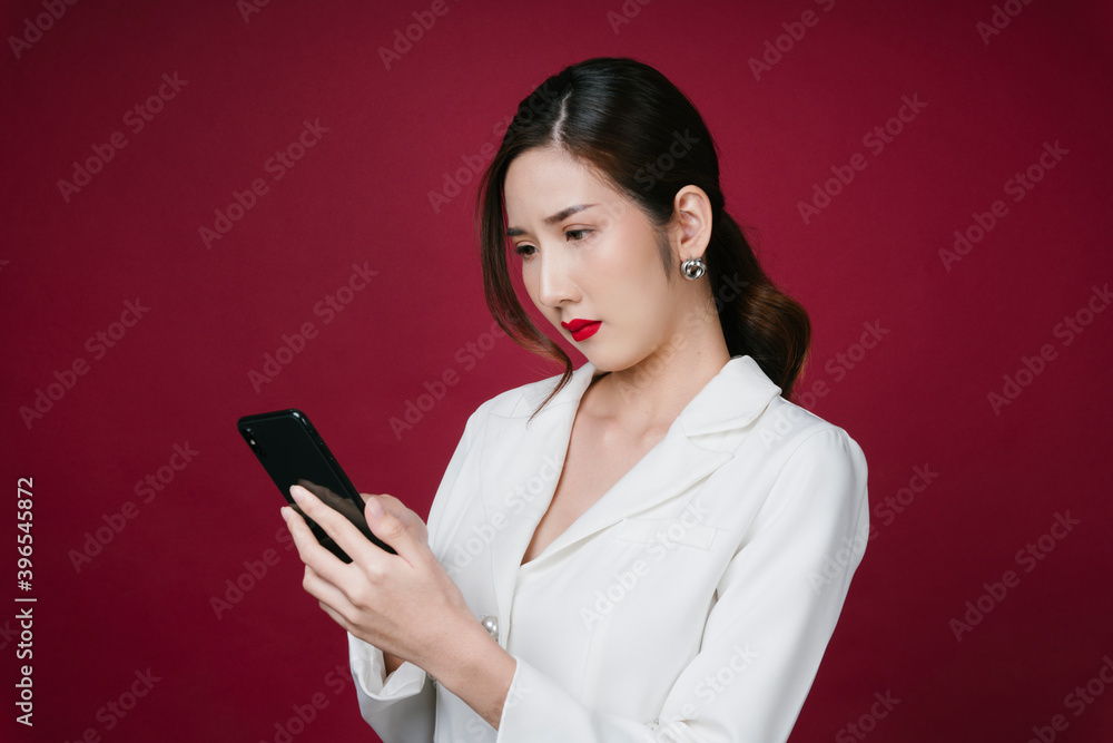 Portrait of beautiful asian woman in white jacket suit using smartphone for cosmetic shopping. Portrait of beautiful asian woman in white jacket suit using smartphone for cosmetic shopping.