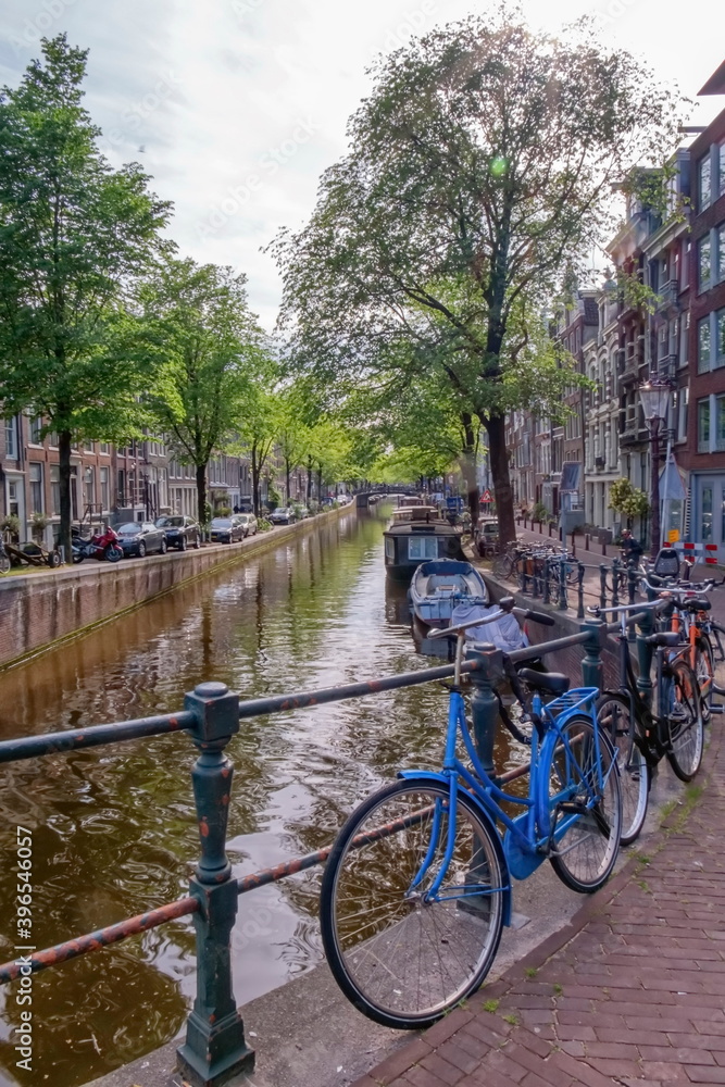 Typical buildings, canal and bikes in Amsterdam by day, Netherlands