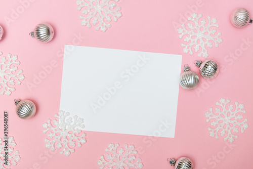 Pink christmas background with snowflakes, decoration balls and empty blank for text, flat lay, copy space