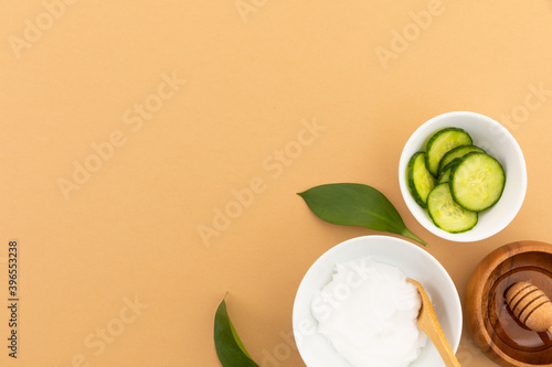 Bowls with yoghurt, cucumber and dressing on yellow background