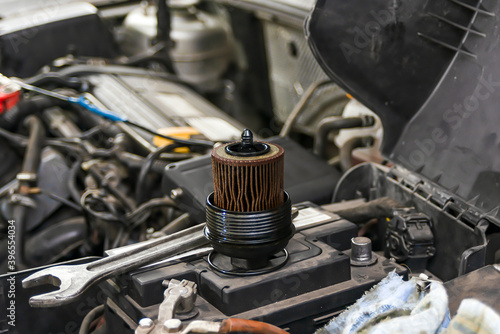 The fuel filter is on the battery from the car with a wrench. photo