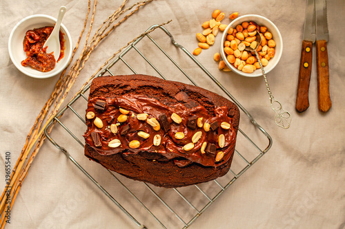 Chocolate Brownies cake with nuts and caramel frosting on wire rack on a light linen cloth. Top view.Christmas baking goods concept