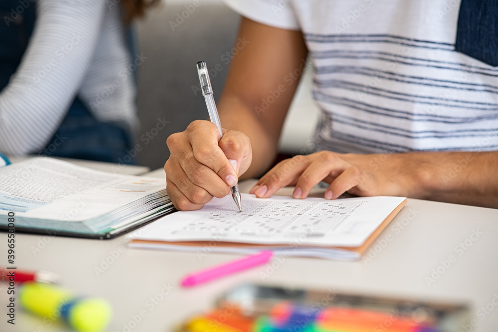 Fototapeta premium High school student filling out test answers with pen