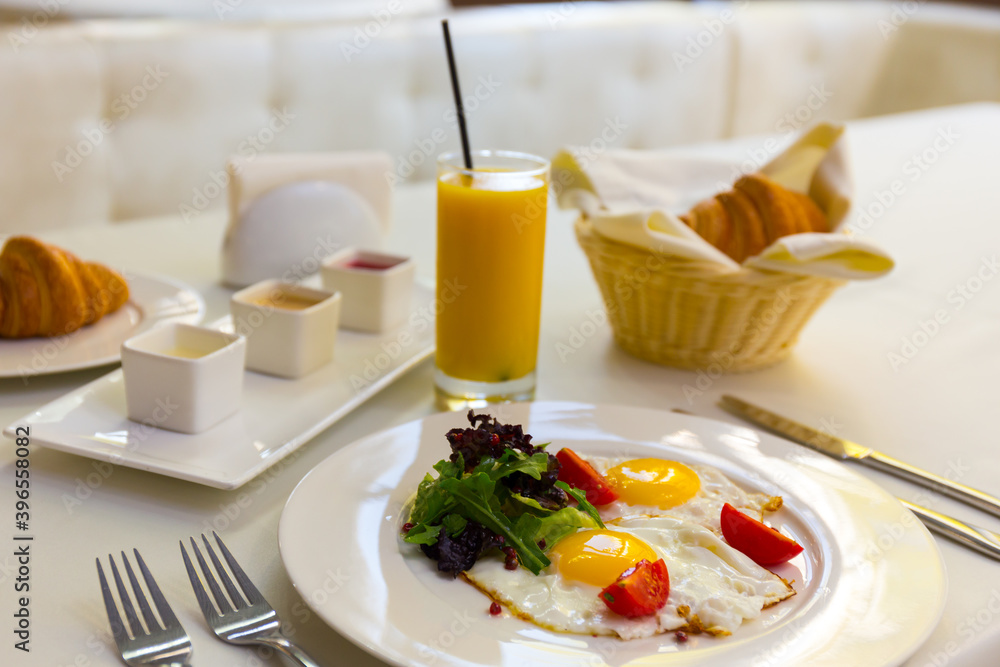 Tasty breakfast with scrambled eggs, juice, croissant and cup of coffe