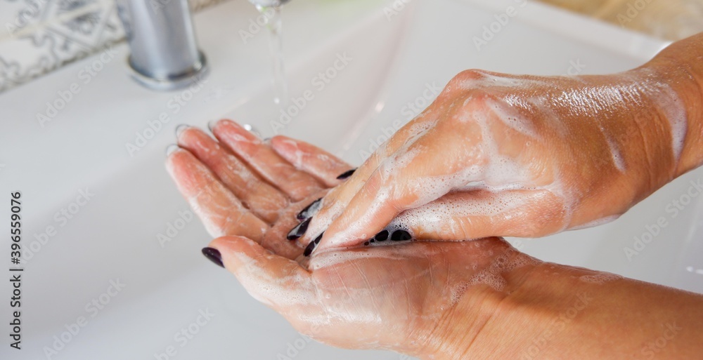 Partial view of woman washing hands at home. Partial view of woman washing hands at home.