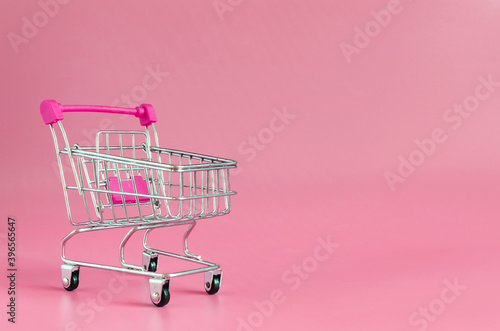 Red empty cart on red background close up trading concept