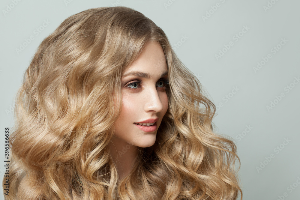 Naklejka premium Beautiful young woman with natural makeup and curly hair close up portrait