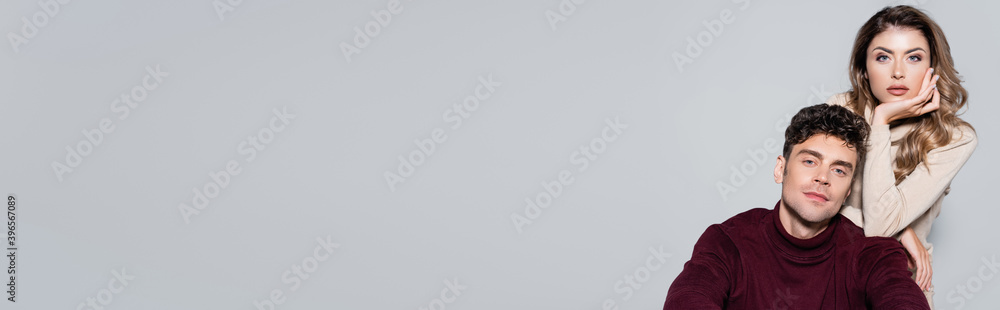 casual young couple in turtleneck jumpers posing isolated on grey, banner casual young couple in turtleneck jumpers posing isolated on grey, banner