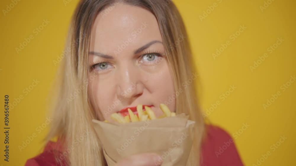 Plump woman enjoys the smell of fries. Close-up Plump woman enjoys the smell of fries. Close-up