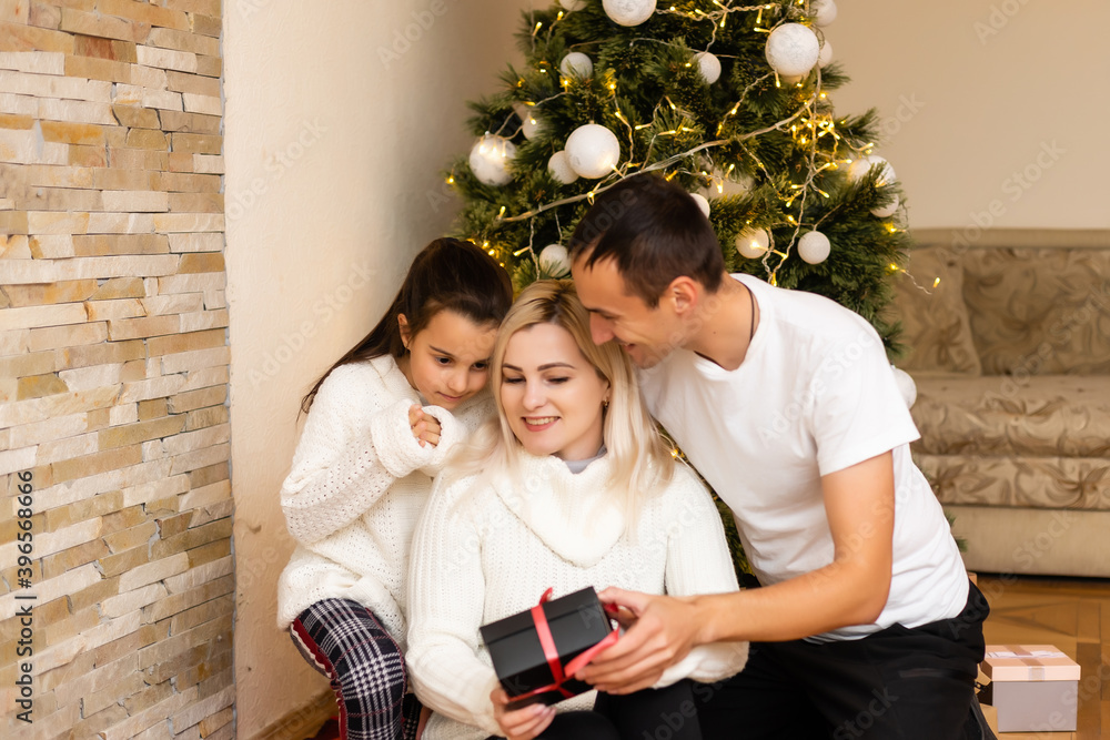 family, holidays and people - smiling mother, father and little girl over christmas tree lights background family, holidays and people - smiling mother, father and little girl over christmas tree lights background