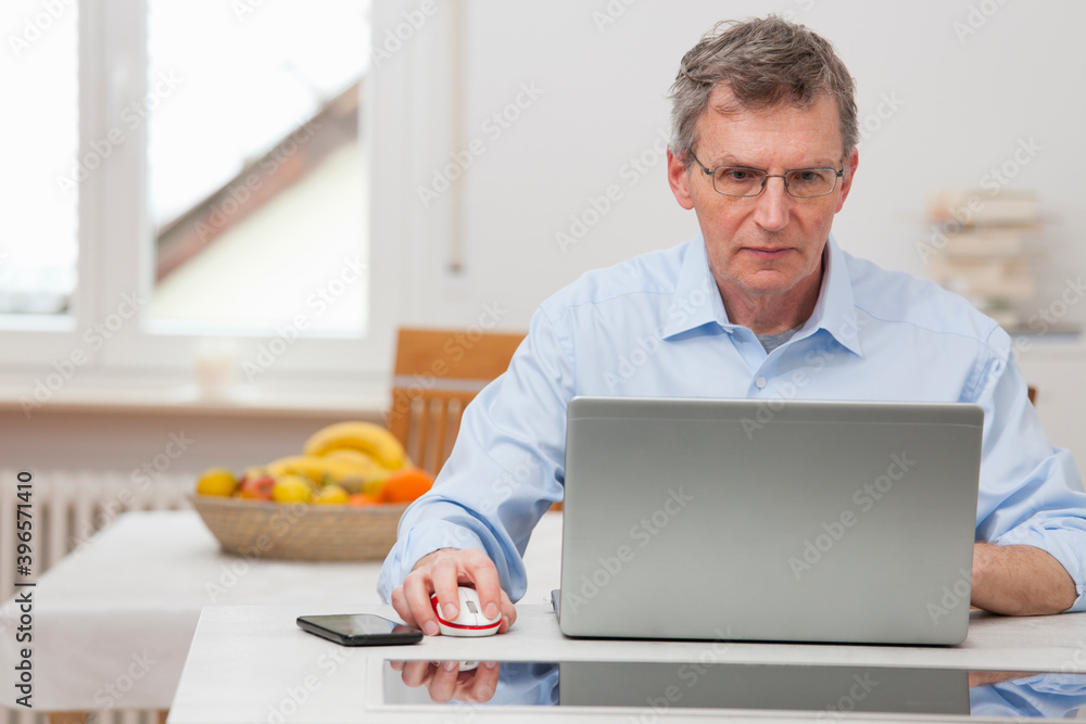 Mature businessman working remote with laptop at home Mature businessman working remote with laptop at home