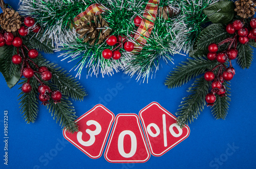 Big sales 30%, thirty percents with Christmas wreath on a dark blue  background, top view, copy space, flat layout. Christmas big sale. © vadim yerofeyev
