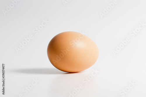 One brown organic fresh raw egg. Cut out and isolated on white background with soft shadows for added dimension.