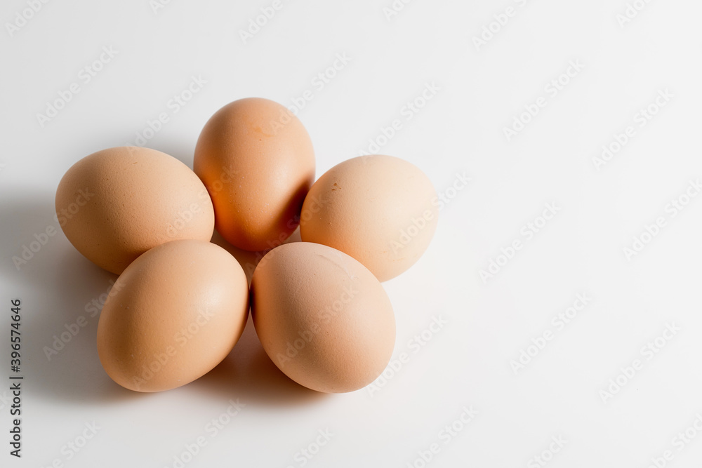 Five brown organic fresh raw eggs. Cut out and isolated on white background with soft shadows for added dimension. Five brown organic fresh raw eggs. Cut out and isolated on white background with soft shadows for added dimension.