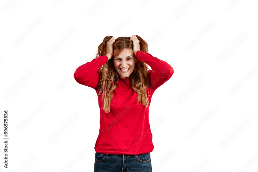 Beautiful young woman dressed in a red sweater, stressed with her hands on her head, isolated on a white background. Beautiful young woman dressed in a red sweater, stressed with her hands on her head, isolated on a white background.