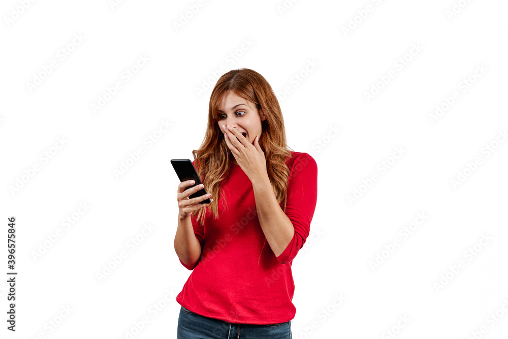 Beautiful young woman in a red sweater, surprised while using on the phone, isolated on a white background. Beautiful young woman in a red sweater, surprised while using on the phone, isolated on a white background.