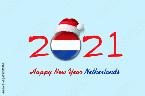 2021. Happy New Year Netherlands. Flag of Netherlands in a round badge, and in a Santa hat. Isolated on a light blue background. Design element.