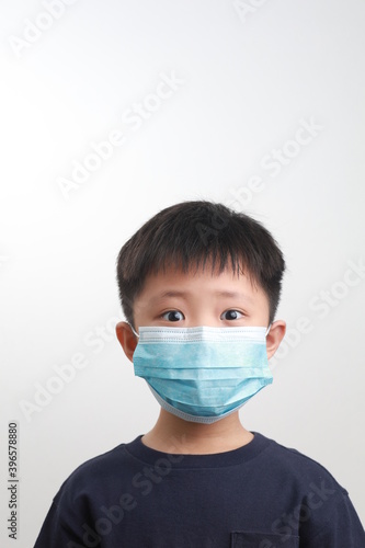 Portrait of 9-year-old boy wearing a protective mask against a white background. Coronavirus, Covid-19 and pandemic concept.