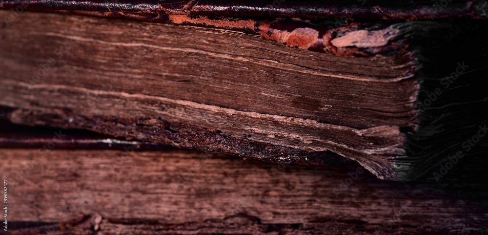 Old worn books in leather cover in the dark. Closeup of the Torah end. Selective focus. Low key.