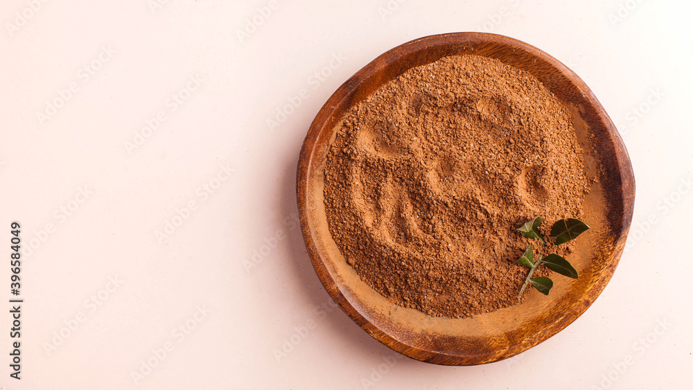 Cocoa powder in a wooden bowl on a pink background. Cocoa product. Copy space. Cocoa powder in a wooden bowl on a pink background. Cocoa product. Copy space.