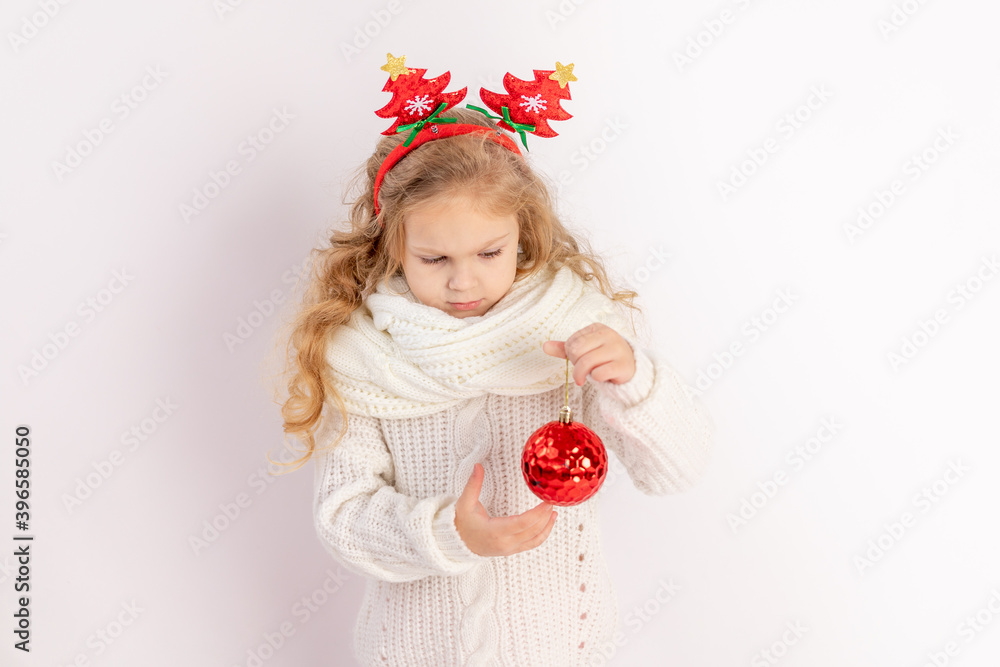 baby girl holding a red Christmas ball on a white isolated background, space for text baby girl holding a red Christmas ball on a white isolated background, space for text