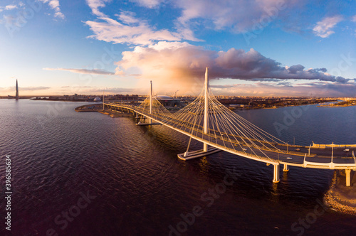 Aerial Panoramic view to evening St. Petersburg and Cable-stayed bridge across Petrovsky fairway. Western high-speed diameter WHSD at sunset. Modern highway along Neva river in a summer day. Russia. © Alex Shirmanov