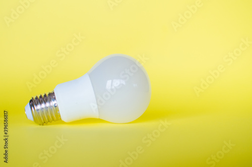 Light Bulb on the left side of the image on a Yellow background. Electricity.
