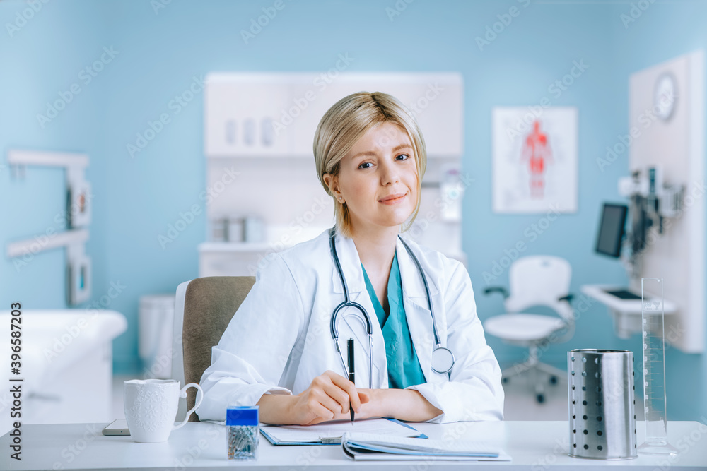 Female Doctor sitting in her Medical Office with Stetoscope Female Doctor sitting in her Medical Office with Stetoscope