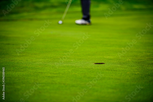 With a putt, hit the hole with the golf ball