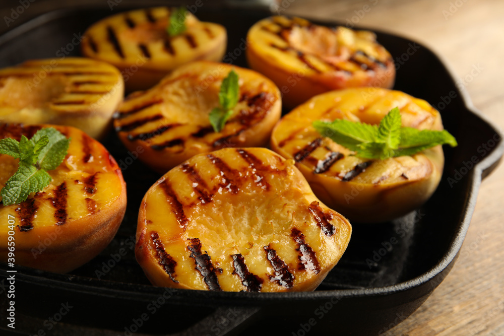 Delicious grilled peaches with mint on table, closeup Delicious grilled peaches with mint on table, closeup