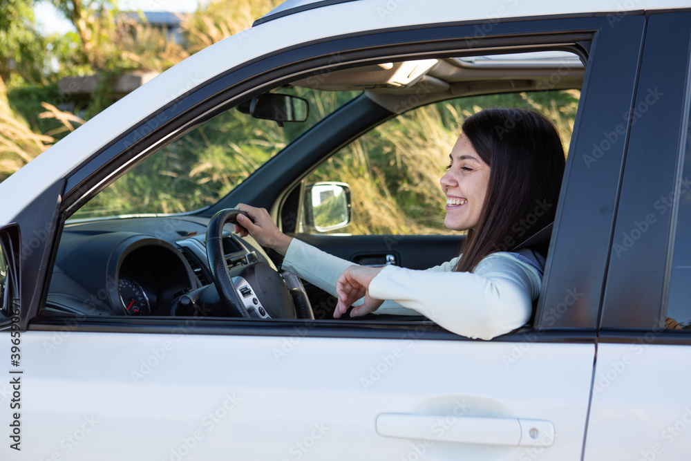 young pretty smiling woman driving car