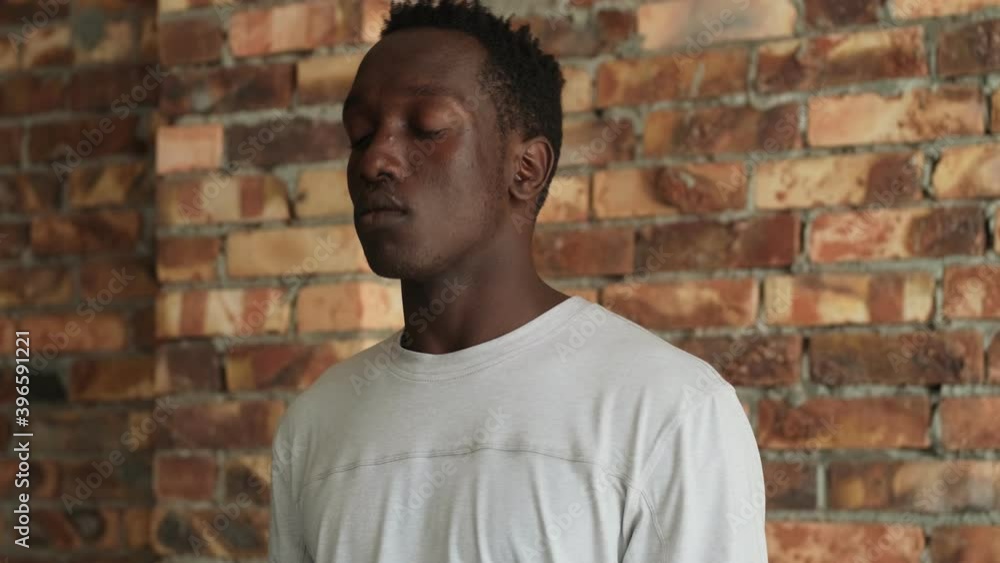 A close-up view of a calm african american man is doing exercises indoors
