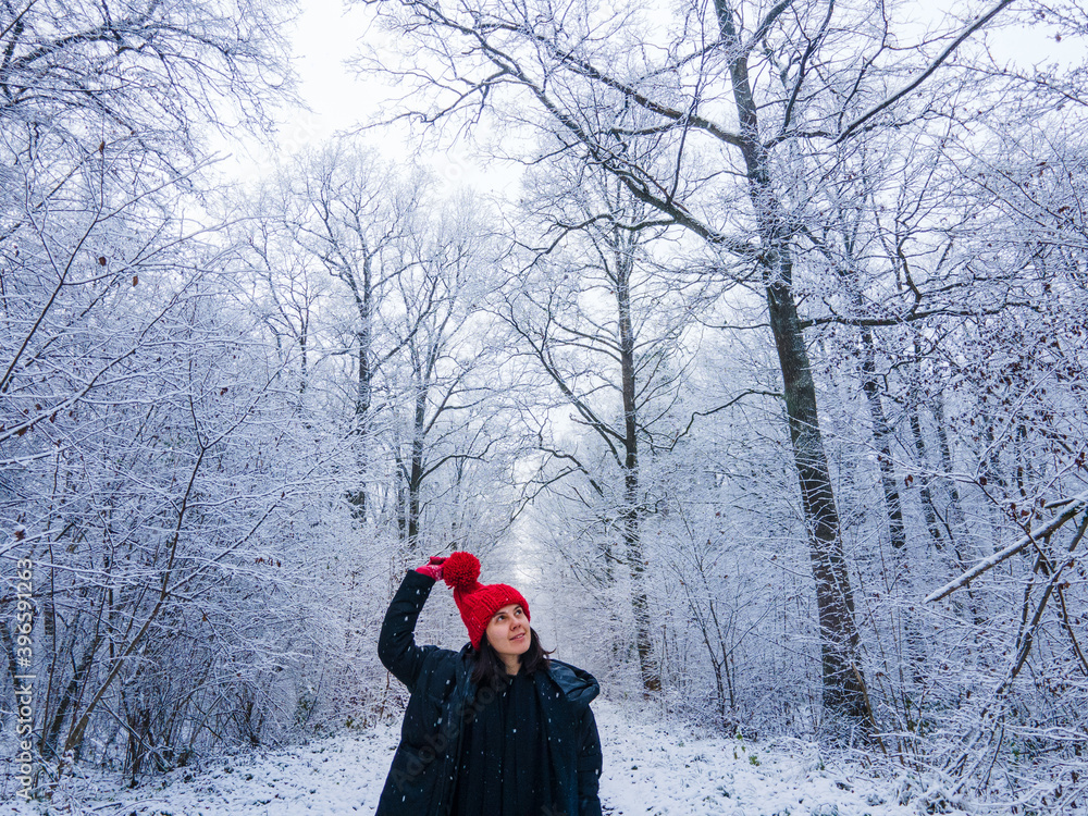 young woman in red hat at winter forest