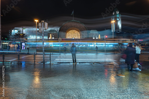 Helsinki, Finland November 30, 2020
Railway station building. During the pandemic, the statues are wearing medical masks. Burning lanterns and reflections after the rain.