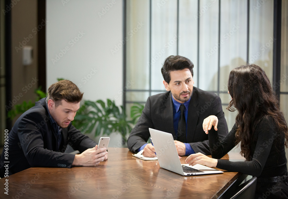 Young business team discussing and studying statistics in a meeting room Young business team discussing and studying statistics in a meeting room