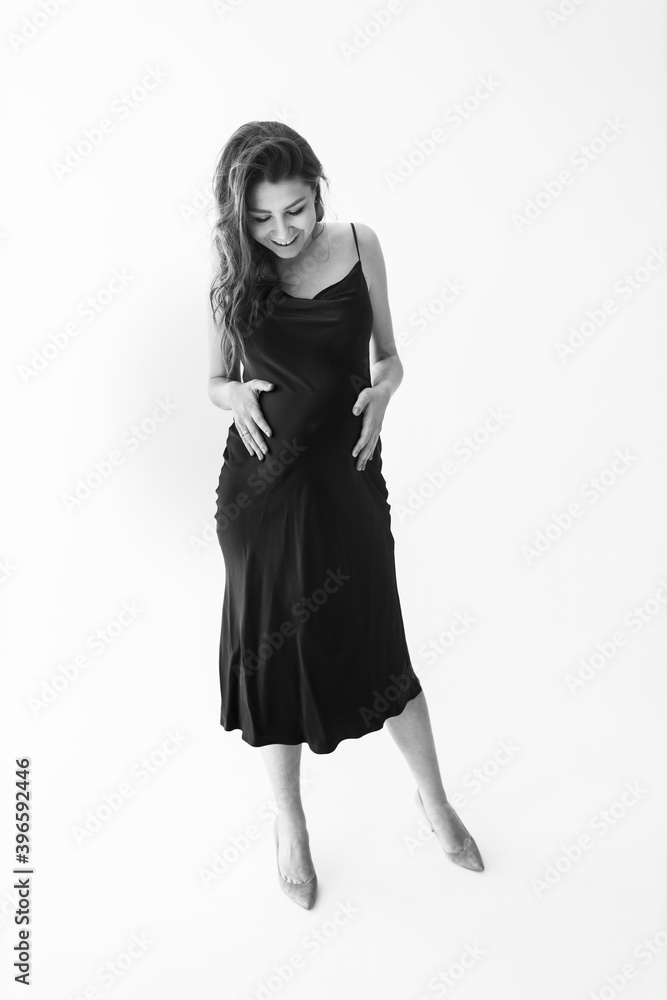 Fashion pregnant woman posing in studio, at the white background, expect for a first baby, wonderful lady excited about motherhood, enjoy happy moments, pregnancy concept Fashion pregnant woman posing in studio, at the white background, expect for a first baby, wonderful lady excited about motherhood, enjoy happy moments, pregnancy concept