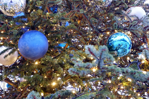 Blue and silver christmas balls and lights on a christmas tree close up view