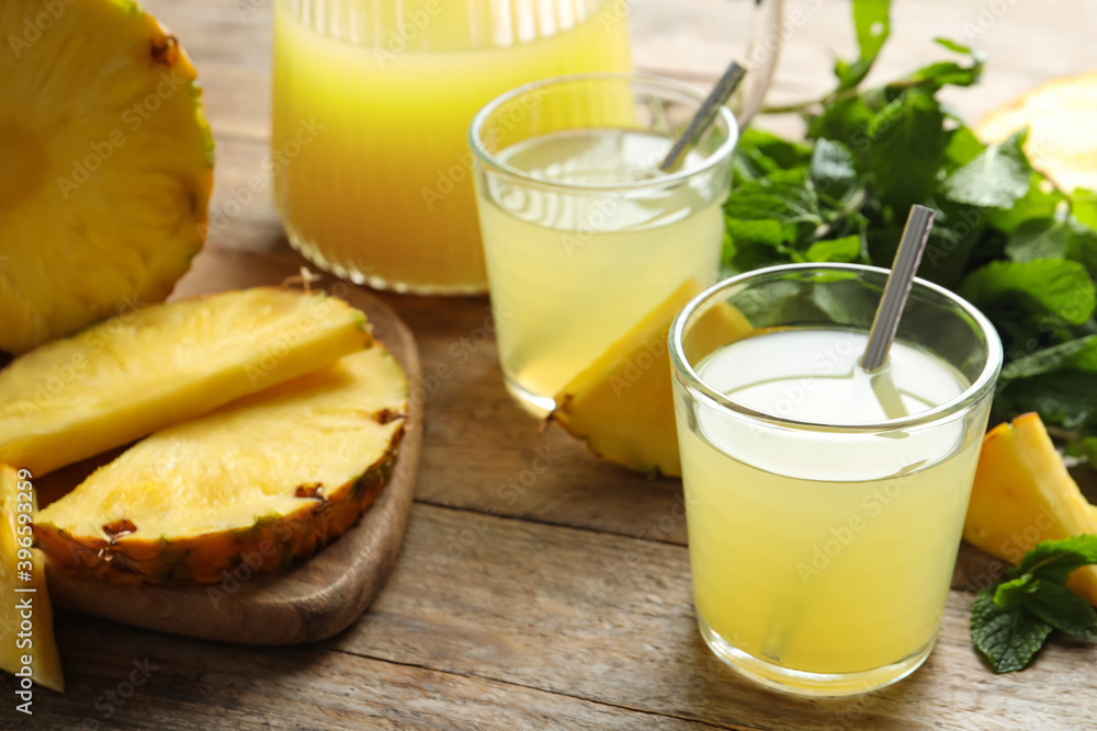 Delicious pineapple juice and fresh fruit on wooden table Delicious pineapple juice and fresh fruit on wooden table