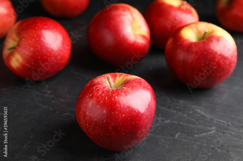 Fresh ripe red apples on black table, closeup