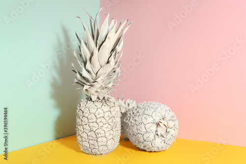 White pineapples on color background, space for text. Creative concept