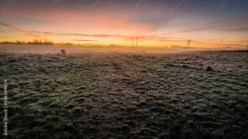 Morning frosty grass on foreground in the morning sunrise autumnal landscape