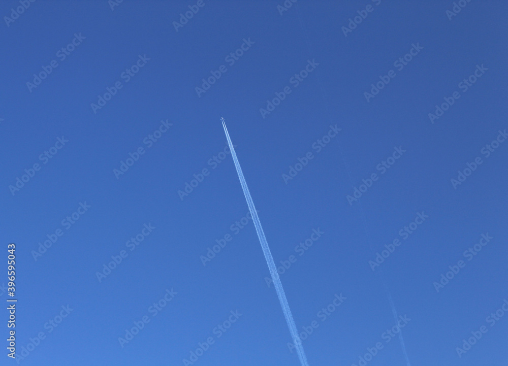 The plane flies diagonally in a clear sky leaving a white mark The plane flies diagonally in a clear sky leaving a white mark