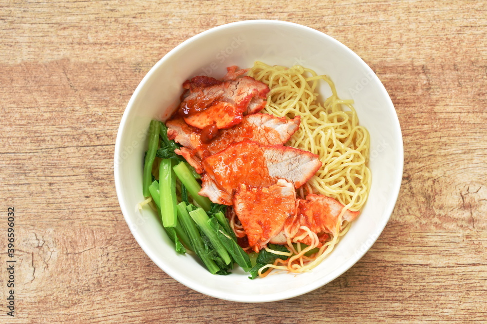 Chinese yellow egg noodles topping slice barbecue pork and boiled cabbage dressing sweet red gravy sauce on bowl Chinese yellow egg noodles topping slice barbecue pork and boiled cabbage dressing sweet red gravy sauce on bowl